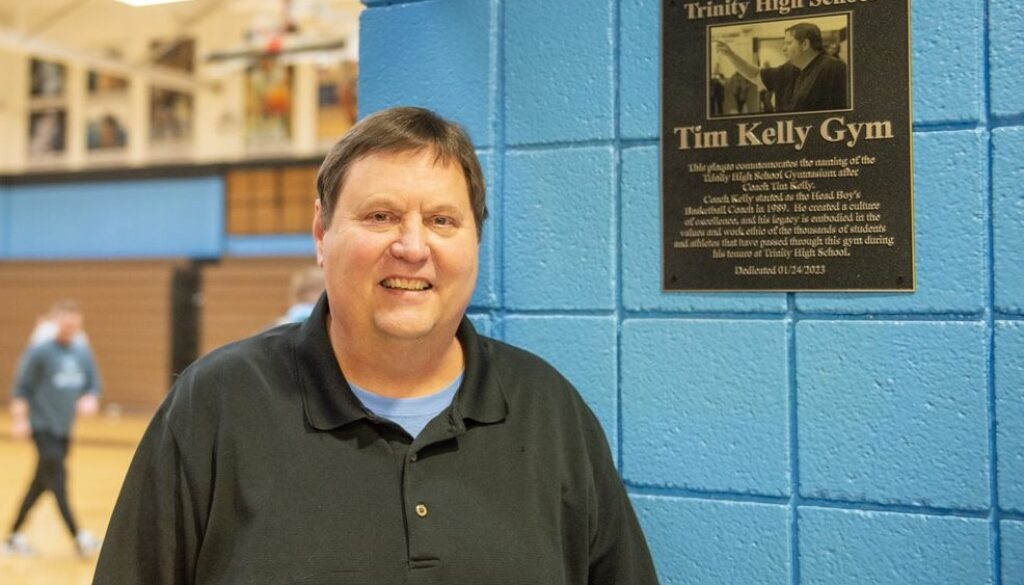 Trinity coach Tim Kelly with gym plaque